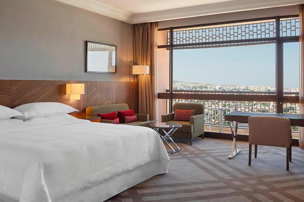 Cette chambre comprend un grand lit et un bureau. dans l'établissement Sheraton Tunis Hotel, à Tunis