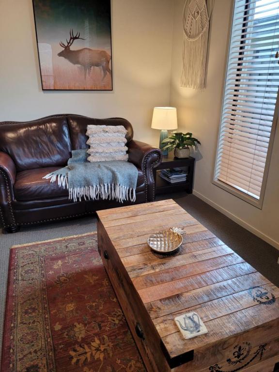a living room with a leather couch and a coffee table at Junction Gem in Ohakune