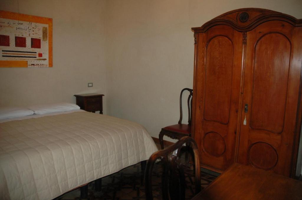 ヴェローナにあるLe Maddaleneのベッドルーム1室(ベッド1台付)、木製キャビネットが備わります。