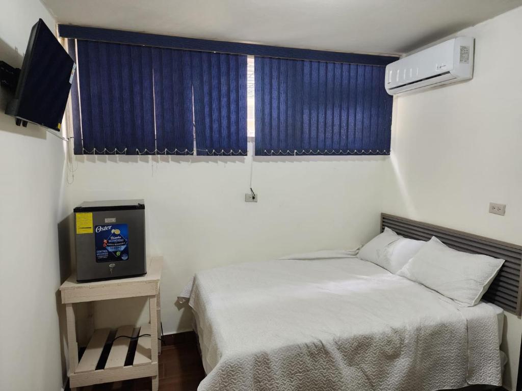 a small bedroom with a bed and a television at GYWEL1214 3 in San Salvador