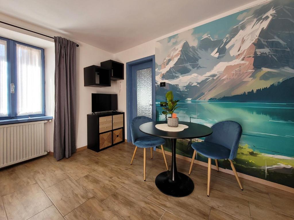 Zimmer mit einem Tisch, 2 Stühlen und einem Gemälde in der Unterkunft Maison AnnaBelle in Ceniga