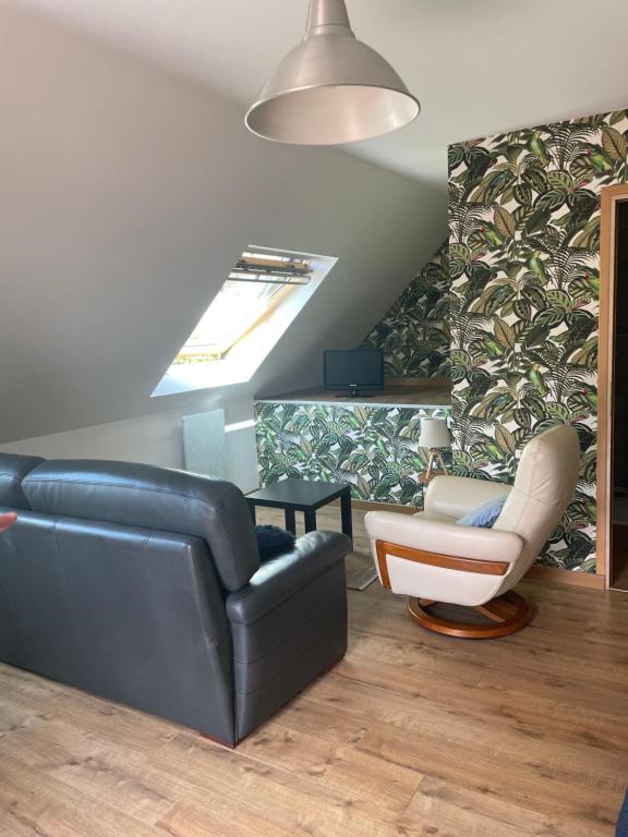 a living room with a couch and a chair at petit studio in Steenbecque