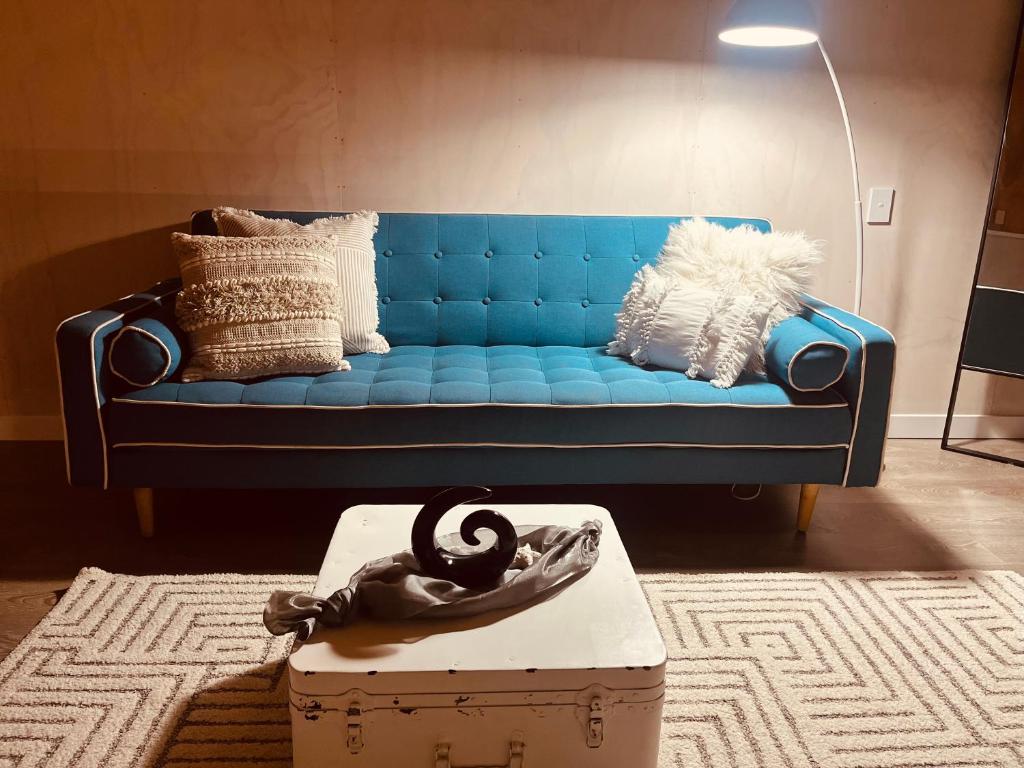 eine blaue Couch in einem Wohnzimmer mit einer Schachtel in der Unterkunft Vitamin Sea Beach House in Riverton