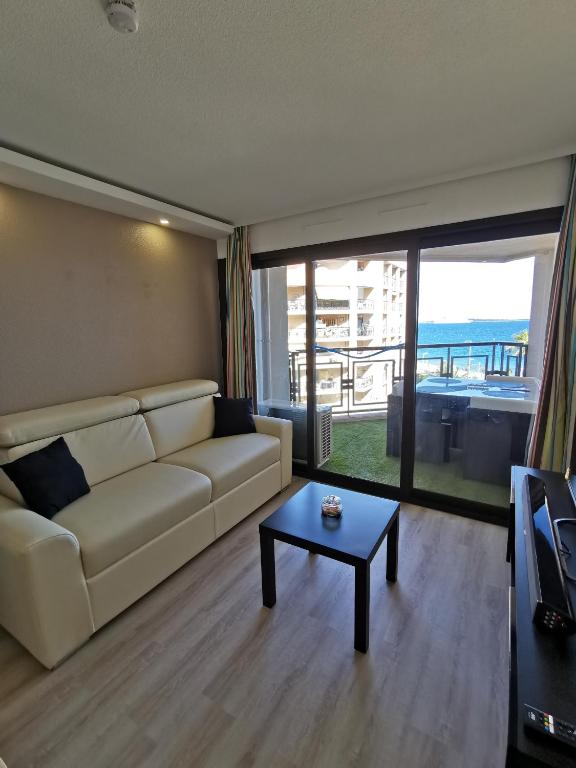 a living room with a couch and a table at Appartement en bord de mer in Cannes