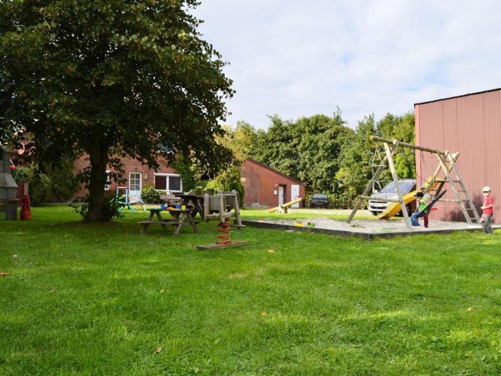 un parque con parque infantil con columpio en Windrose Comfortable holiday residence en Norddeich