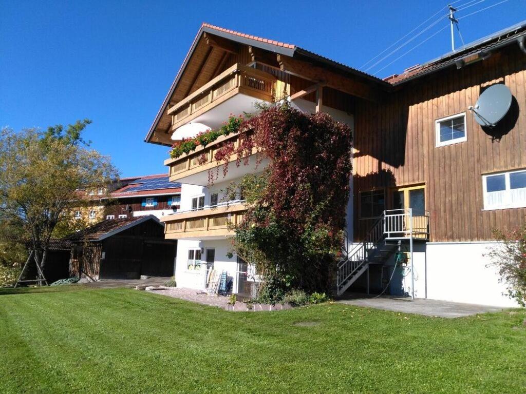 um edifício com um pátio verde em frente em Alpine Lodge Comfortable holiday residence em Wertach