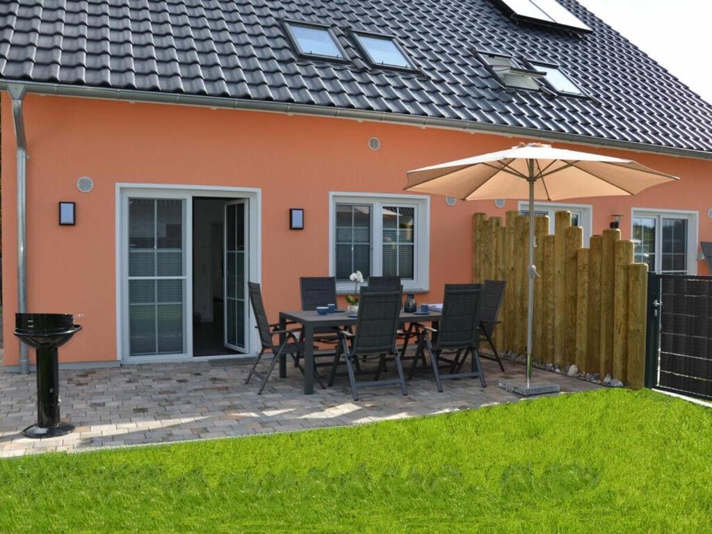a patio with a table and chairs and an umbrella at Starfish Comfortable holiday residence in Breege