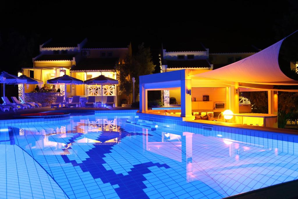 a swimming pool at night with people in it at Sea Sun in Plomari