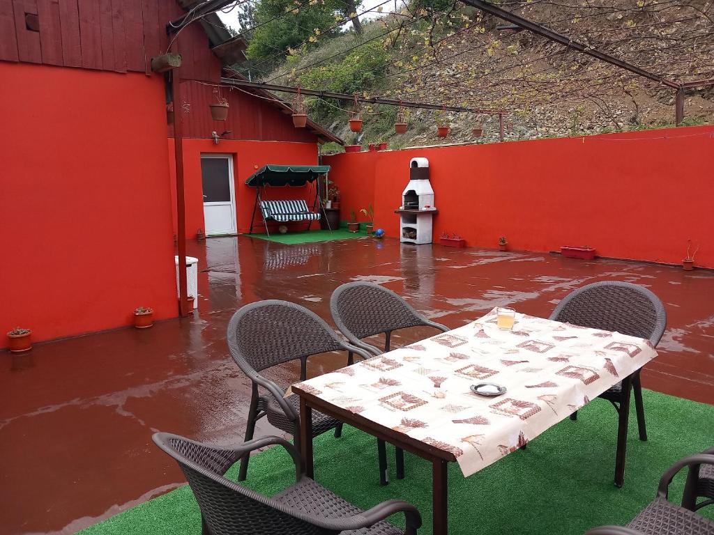 a table and chairs in a red building with water at casa de vacanta in Eibenthal