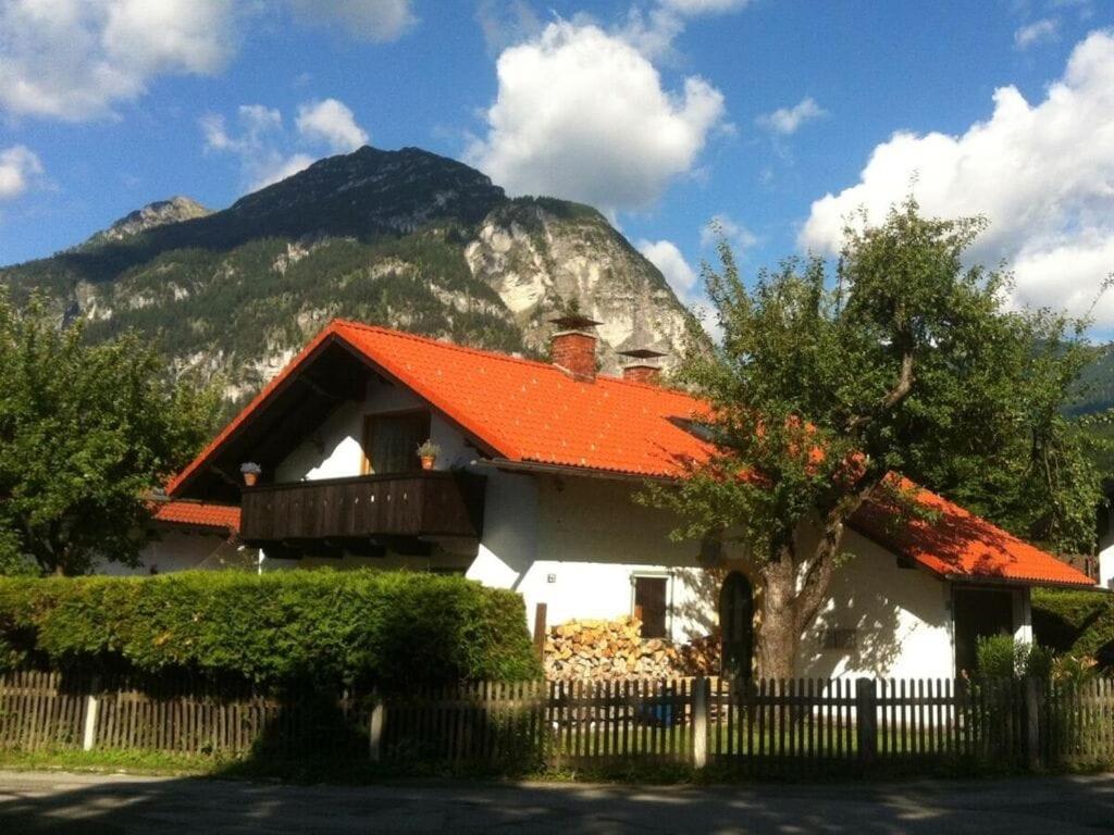 une maison avec un toit orange en face d'une montagne dans l'établissement Greif Comfortable holiday residence, à Garmisch-Partenkirchen