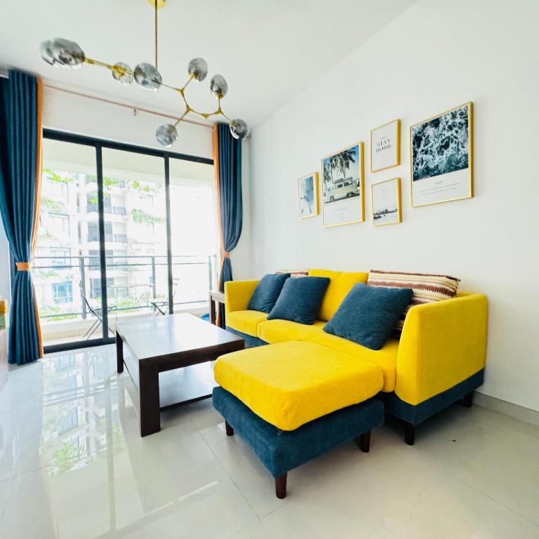 a living room with a yellow couch and a table at Cozy 2B1R condo Forest City in Gelang Patah