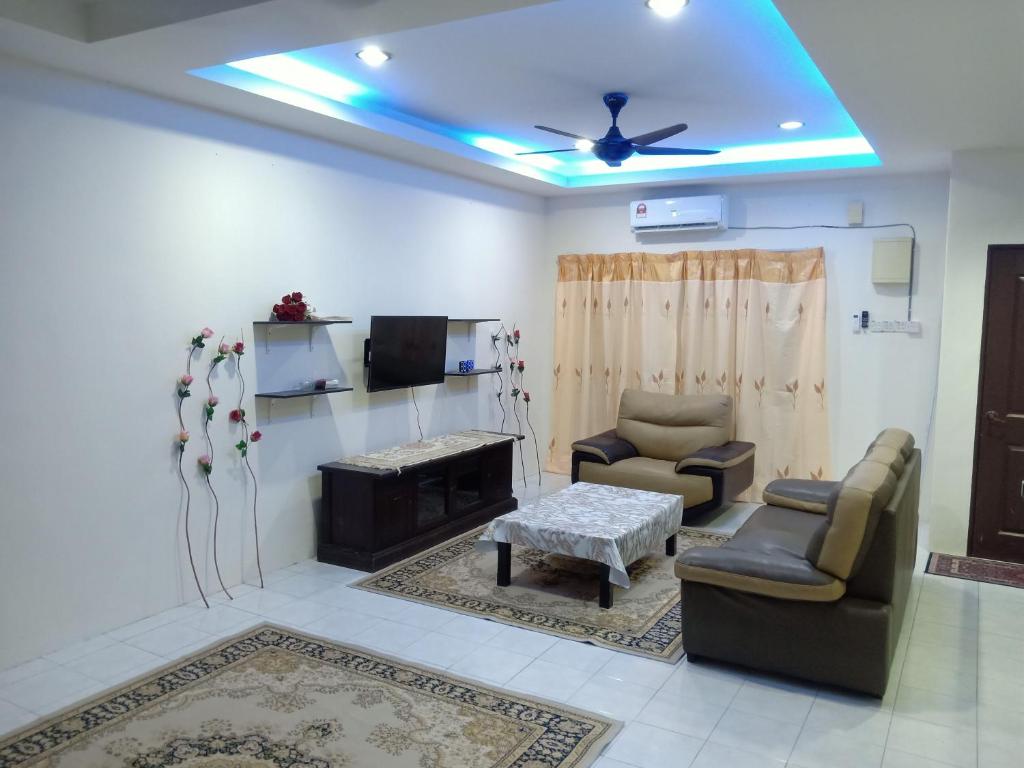 een woonkamer met 2 stoelen en een televisie bij Salak Indah Homestay KLIA/KLIA2 in Sepang