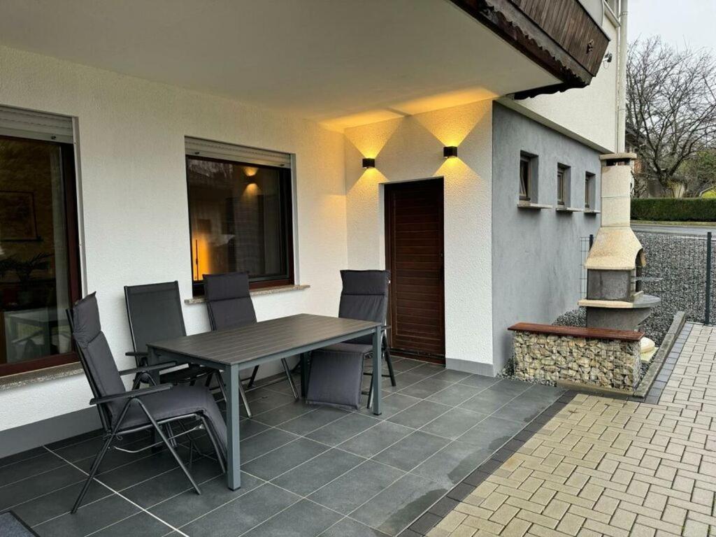 een patio met een tafel en stoelen op een huis bij Lovely apartment near the water in Weilburg
