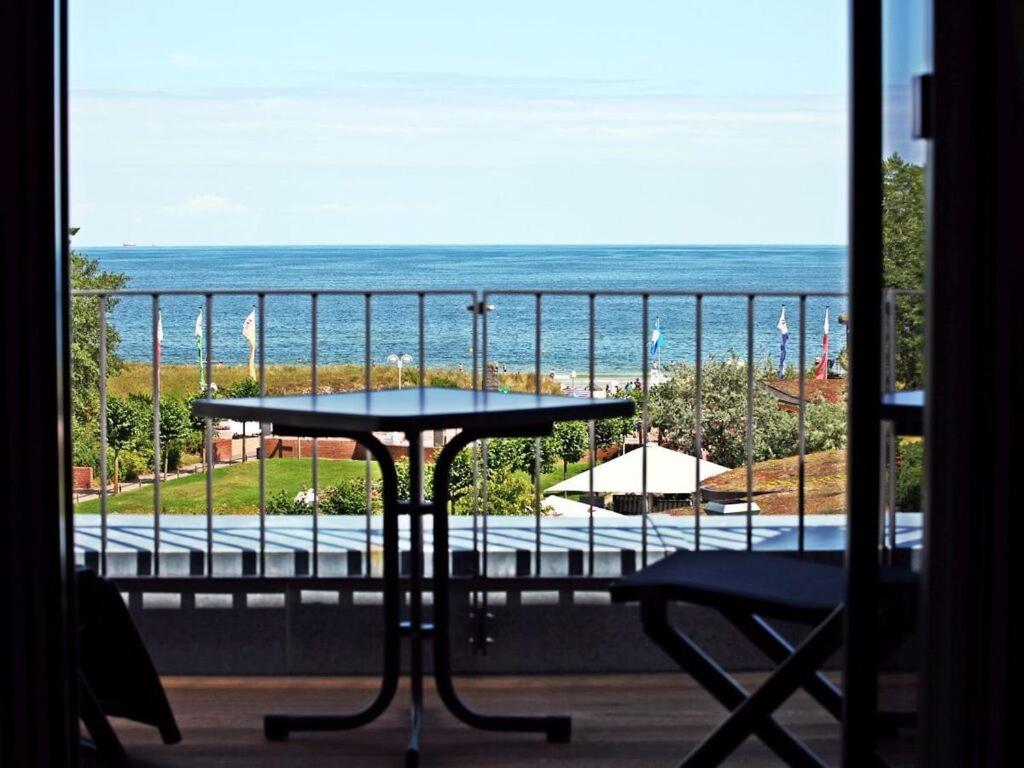 a table on a balcony with a view of the ocean at Villa Düne "Penthouse Apartment" in Baabe