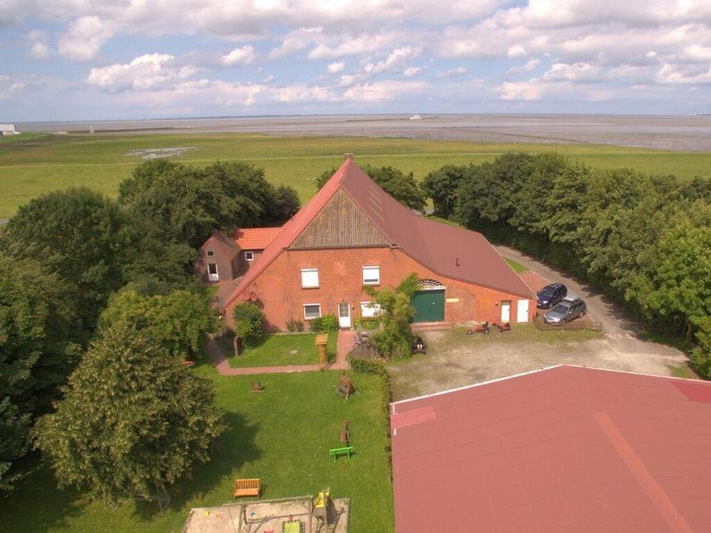 an aerial view of a house in a field at Farmhouse Comfortable holiday residence in Norddeich
