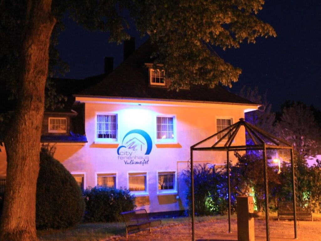 a building with a lit up sign in front of it at Vulkaneifel Comfortable holiday residence in Daun