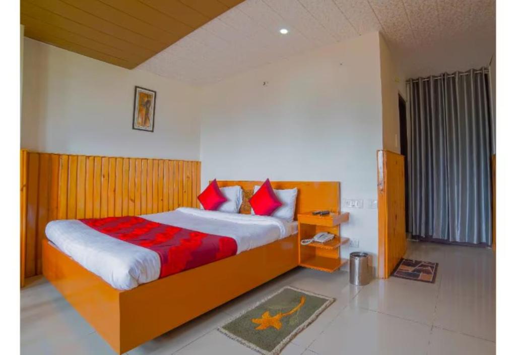 una camera da letto con un grande letto con cuscini rossi di Goroomgo Bala Paradise Munsyari a Munsyari