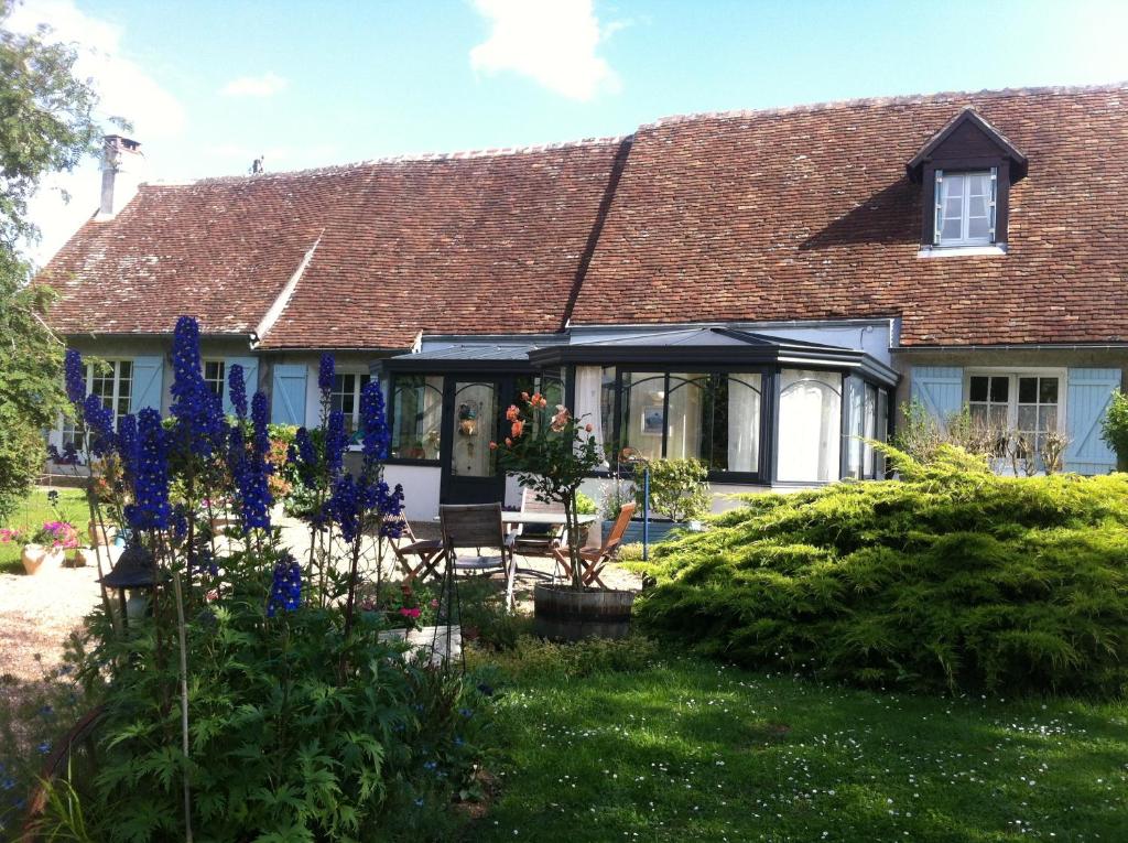 una casa con fiori blu nel cortile di Domaine de la chapelle - Ch d'hote a Faverolles-sur-Cher