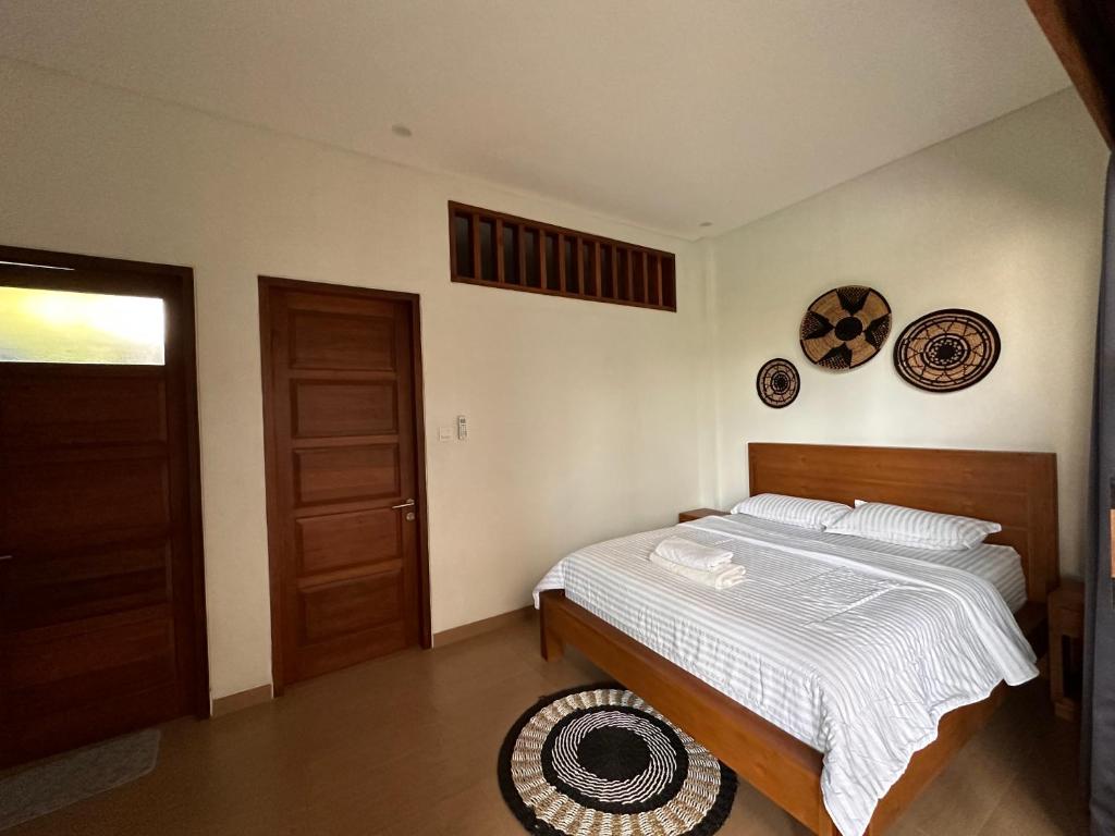 ein Schlafzimmer mit einem Bett und einer Tür und Tellern an der Wand in der Unterkunft Villa Son Sun in Uluwatu
