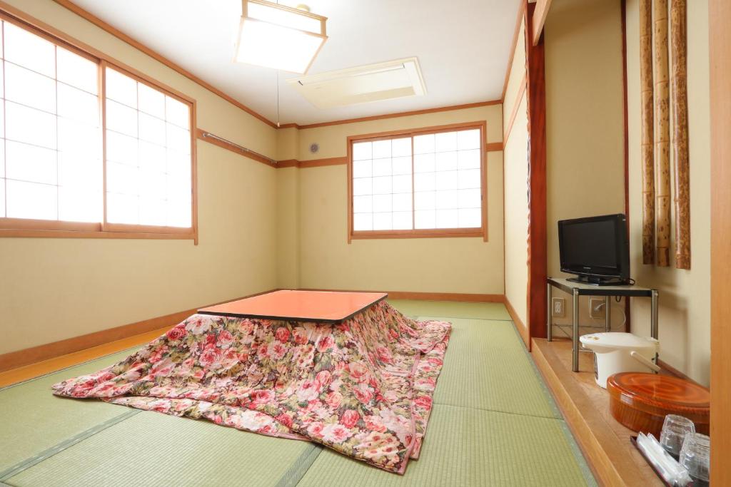 Muraoka的住宿－Ryokan Nakaya，一间铺有地毯的客房,配有电视