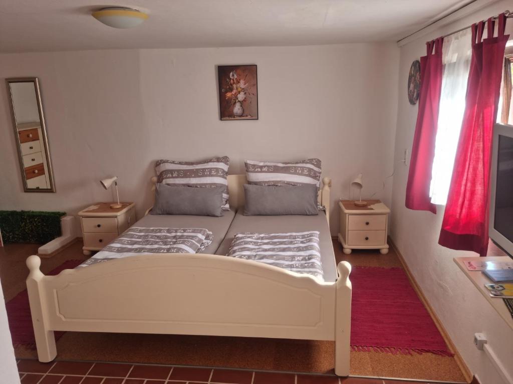 a bedroom with a bed and a tv in it at Ferienwohnung Kefeder in Lochenhaus