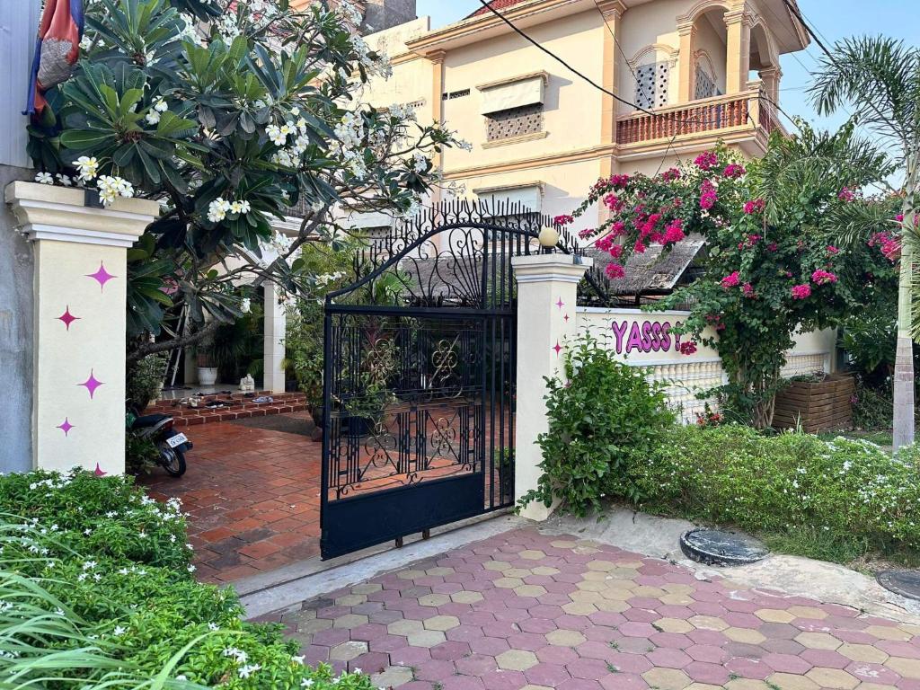 Una puerta a una casa con flores. en YASSS LGBTQ Guesthouse Siem Reap en Siem Reap