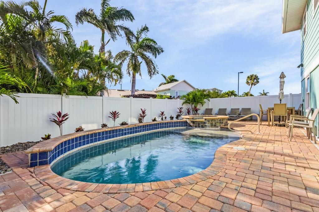 una piscina con patio y valla en Amber Jack - 210 Ostego Dr home, en Fort Myers Beach
