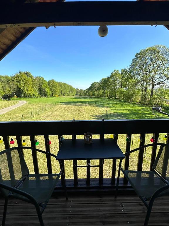 - une table sur une terrasse couverte avec vue sur un champ dans l'établissement Very Peaceful Larchamp. Dogs Welcome, à Larchamp