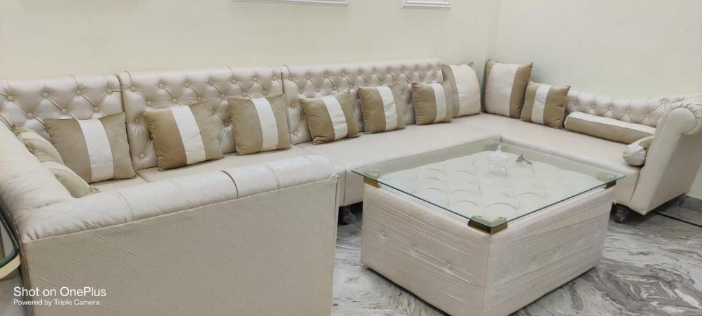 a white couch with pillows on it in a room at Indipendent Home Stay at Jankupuram Lucknow in Lucknow