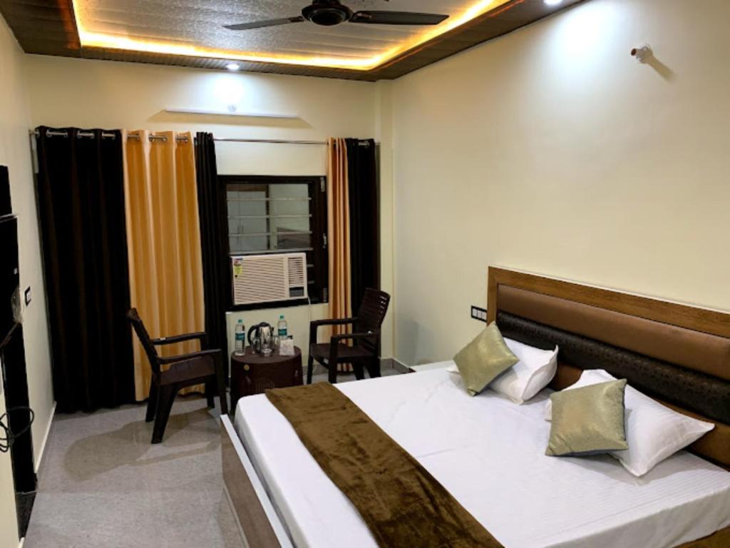 Schlafzimmer mit einem Bett, einem Tisch und Stühlen in der Unterkunft Goroomgo Tapovan Residency Haridwar - Excellent Service Recommended in Haridwar