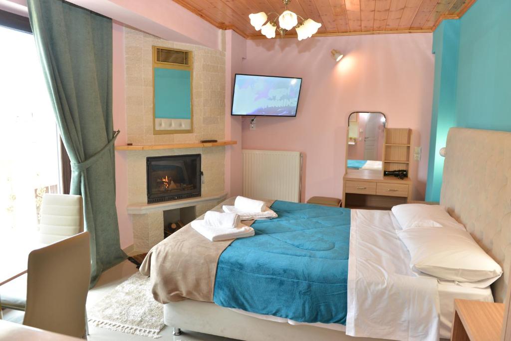 um quarto com uma cama azul e uma lareira em tokastro em Arachova