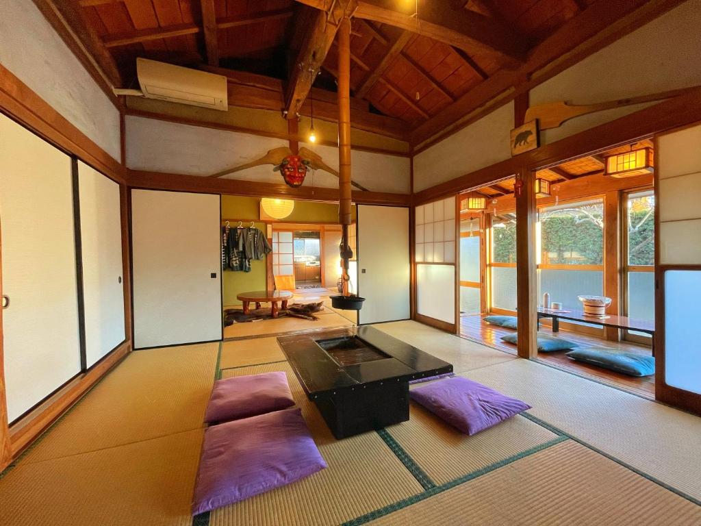een woonkamer met een tafel en paarse matten bij いろり庵 in Tateyama