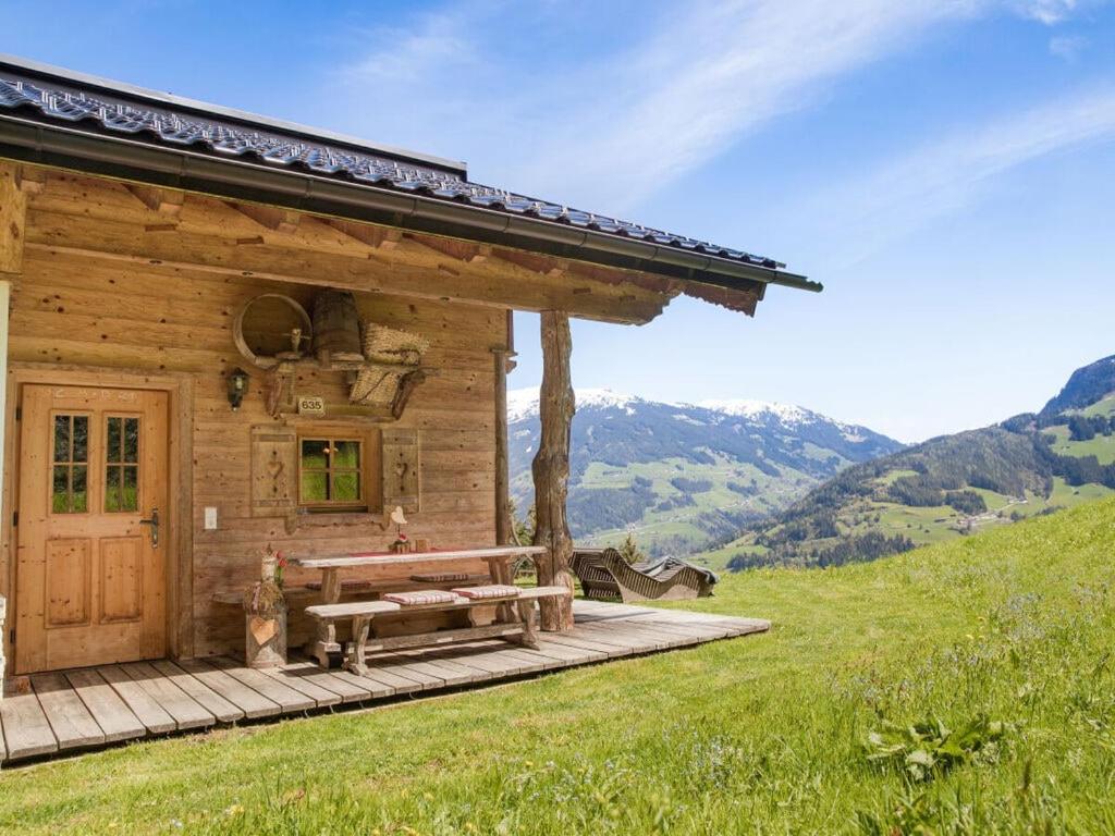 a wooden cabin on a hill with a bench at Alpine Chalet Bergkristall in Hippach