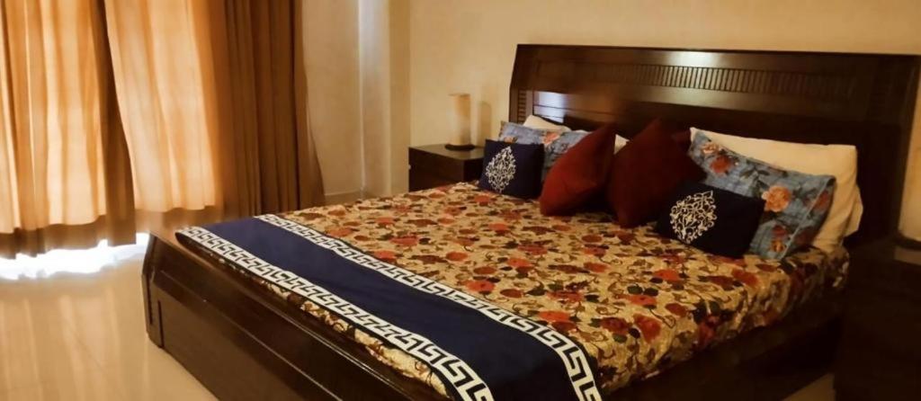 a bedroom with a large bed with pillows at AL KHALEEJ HOTEL in Murree