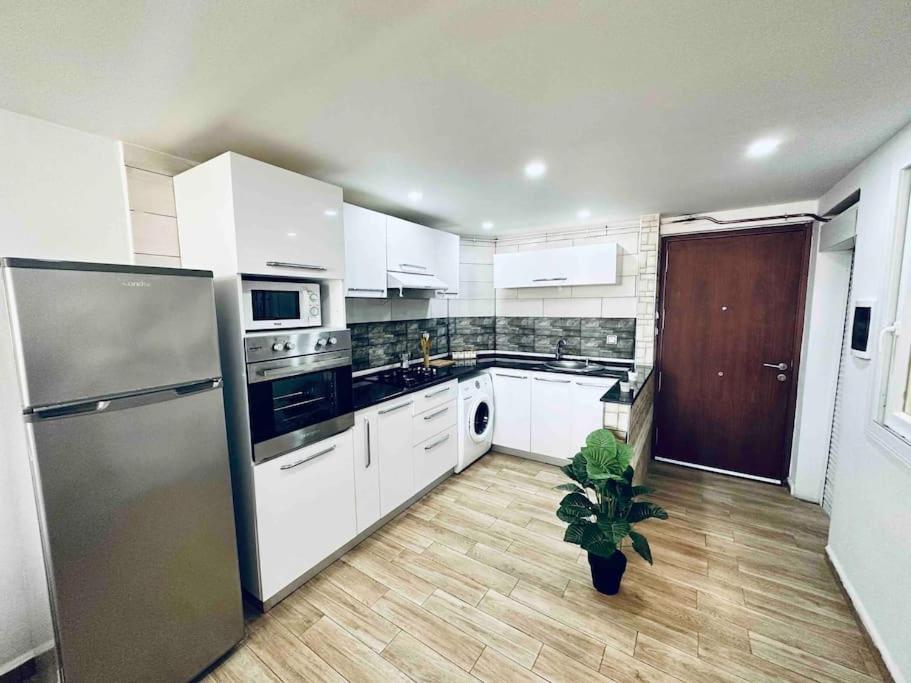 a kitchen with white appliances and a potted plant at Superbe appartement au cœur de Jijel in Jijel