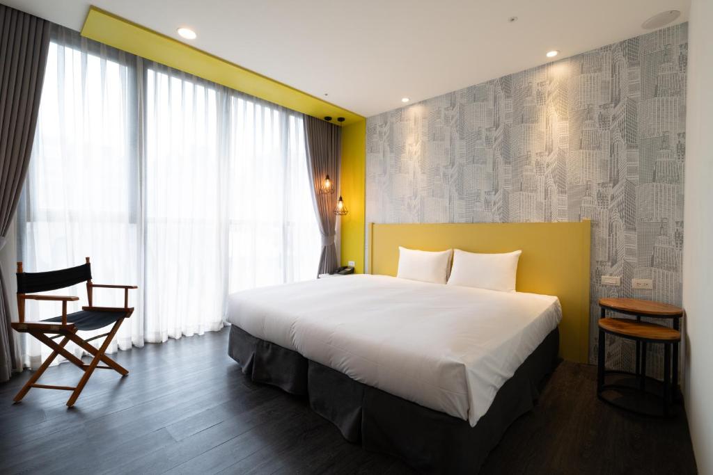 pokój hotelowy z dużym łóżkiem i oknem w obiekcie 凝萃文旅台中車站店 NCH - NingCui Business Hotel w mieście Taizhong