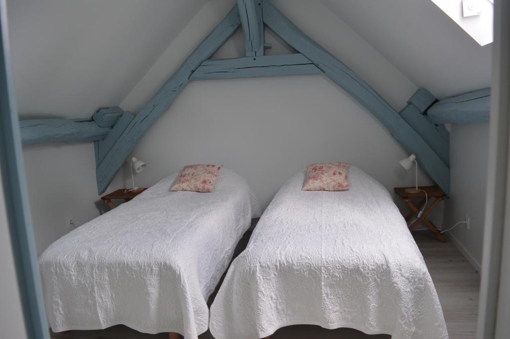 2 Betten im Dachgeschoss mit weißer Bettwäsche in der Unterkunft Gîte de charme, grand confort in Marolles-sous-Lignières
