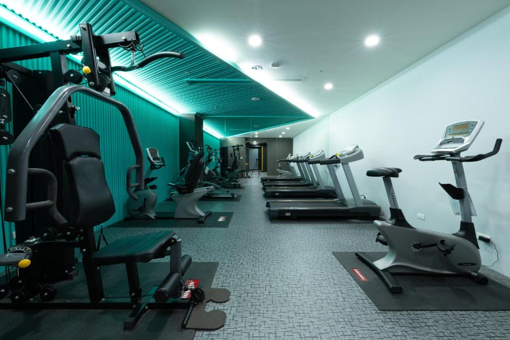 a gym with a row of treadms and cardio machines at 凝萃文旅 台中車站店 NCH-Business Hotel in Taichung