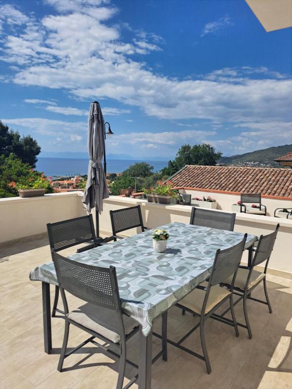 stół z krzesłami i parasol na patio w obiekcie Costamia Casa Vacanze w mieście Santa Maria di Castellabate