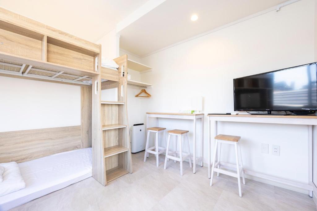 福岡市にあるtomaribaの二段ベッド1台、薄型テレビが備わる客室です。