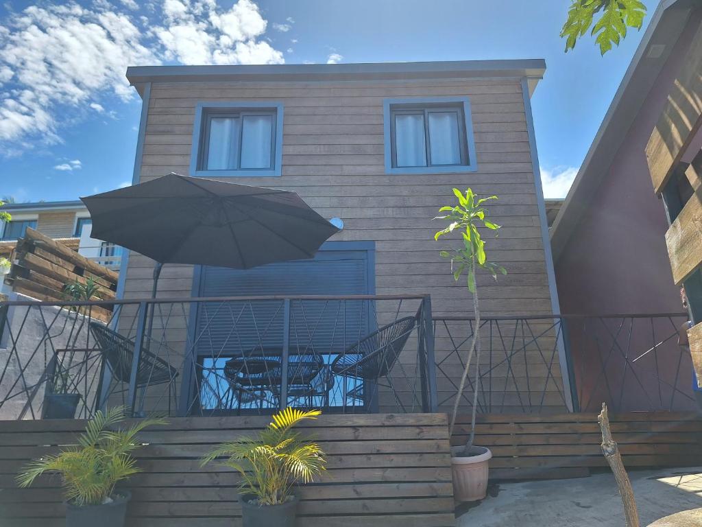 Cette maison dispose d'une terrasse avec un parasol. dans l'établissement Bungalow tiayo, à Saint-Leu
