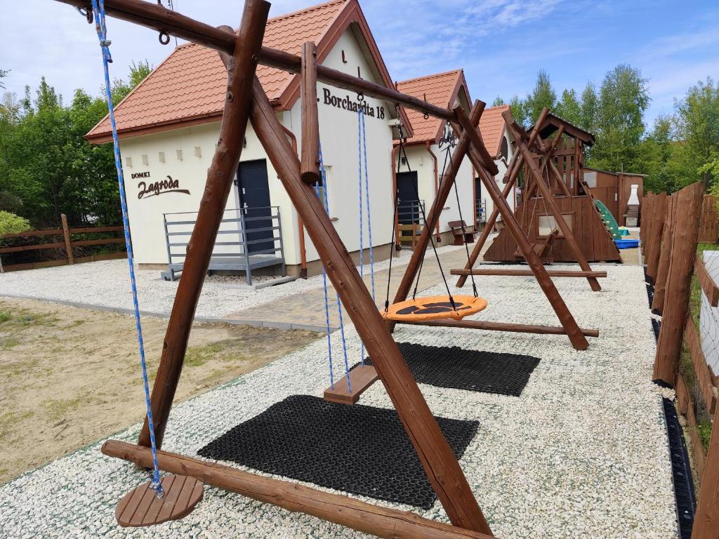 a swing set at a playground in front of a building at Domki Zagroda in Jastrzębia Góra
