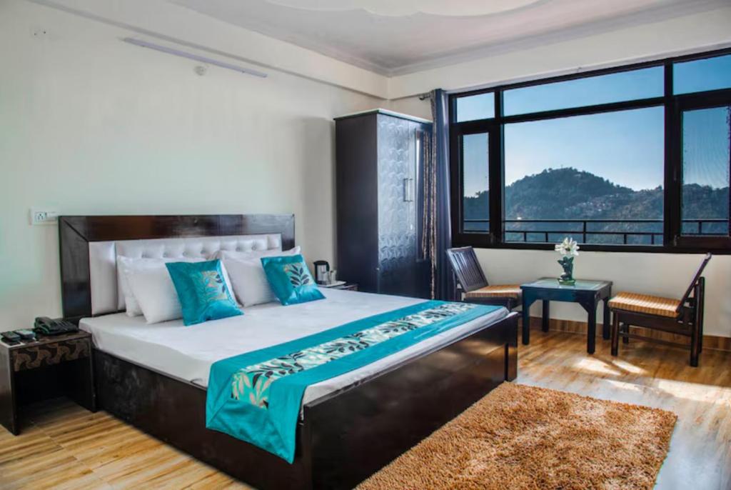 Goroomgo शिमला Nature Ville - A Luxury Collection في شيملا: غرفة نوم بسرير ومكتب ونافذة