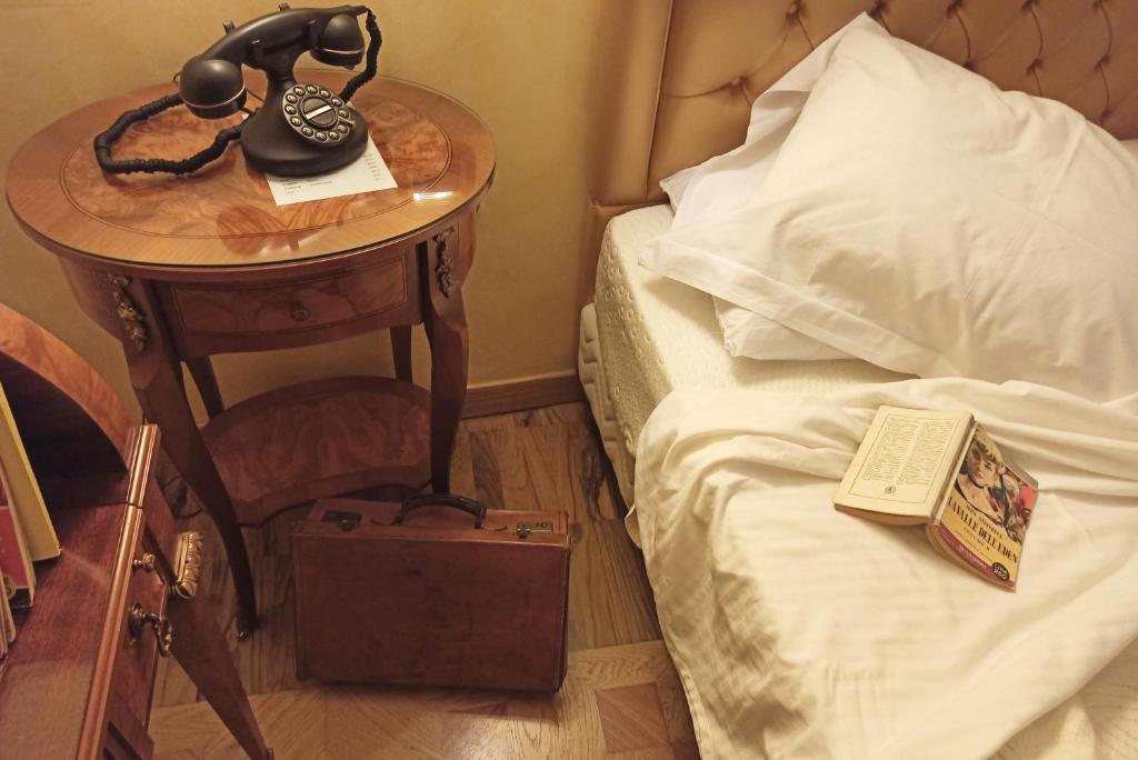 a telephone on a table next to a bed at Blao boutique hotel in Oristano