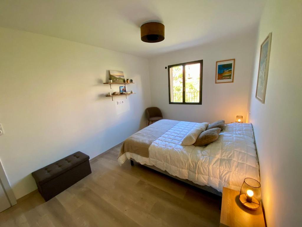 a bedroom with a bed and a window at Piana - vue mer et village in Piana
