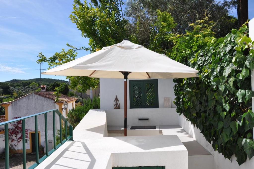 a white umbrella sitting on a balcony next to a fence at Casa Flor de Lis, Sardoal in Sardoal