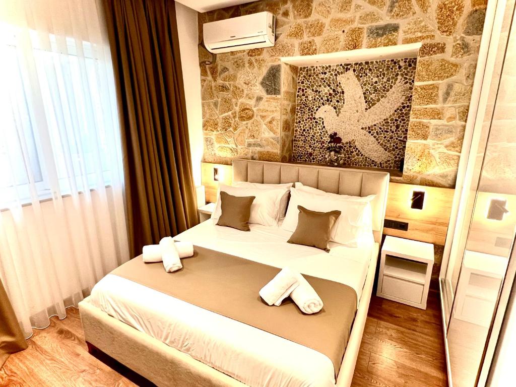1 dormitorio con 1 cama blanca grande y toallas. en ILLYRIAN hotel, en Ksamil