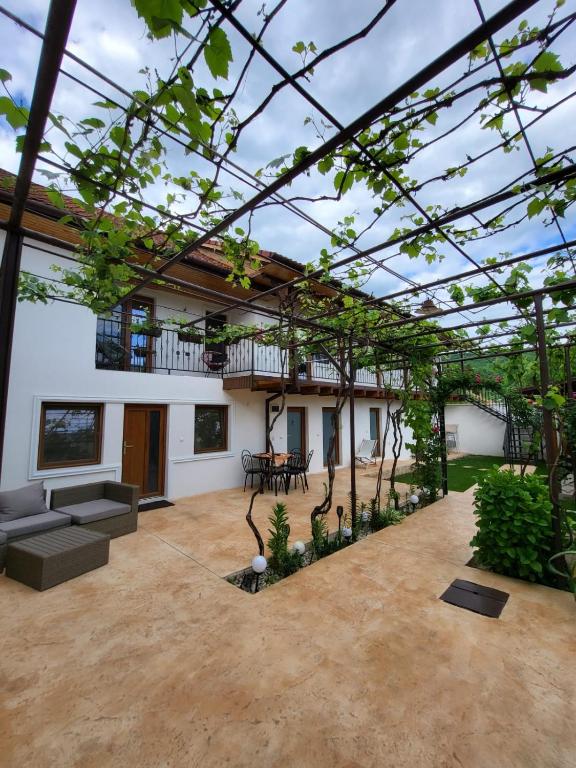 a garden with a pergola and a patio at CASA DIN SAT in Eşelniţa