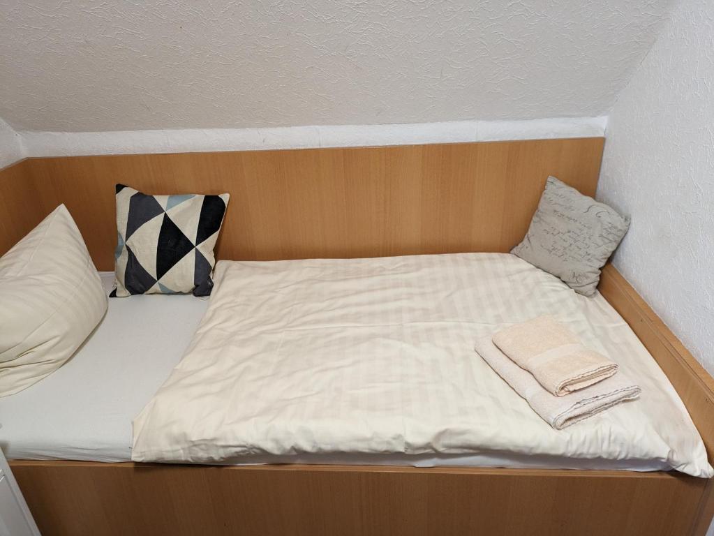 a small bed with white sheets and pillows on it at Kuscheliges Mini-Vintage-Zimmer in Felsberg