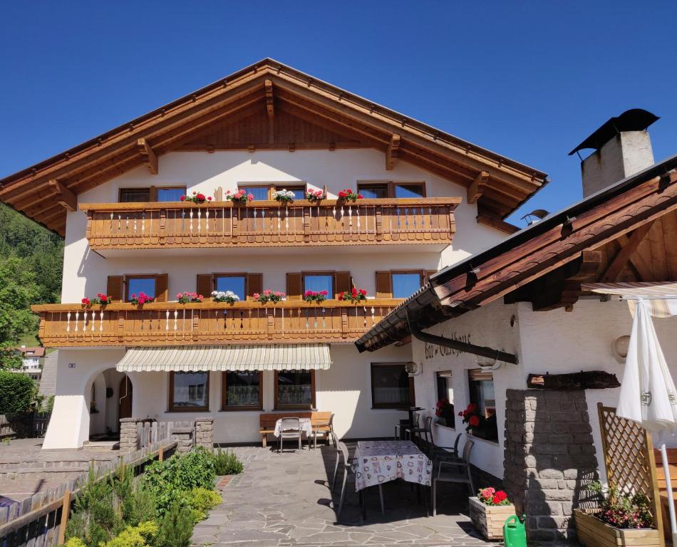 a house with a balcony with flowers on it at Gasthaus Alpenflora in Auna di Sopra